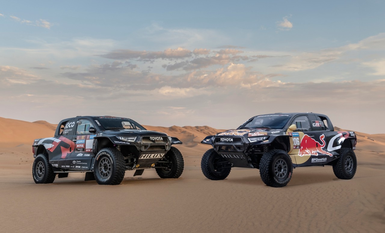 Statické 3/4 záběry závodních vozů Toyota Hilux v poušti